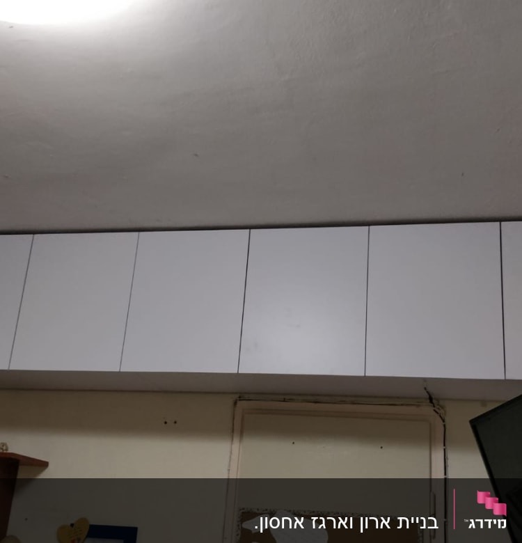 ארונות עץ לבנים מותקנים על הקיר